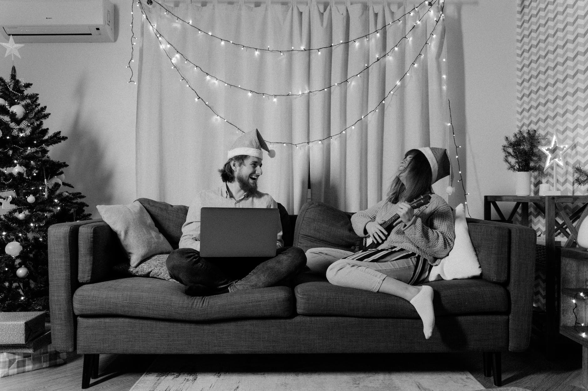 black and white photo of a couple in a sofa during christmas