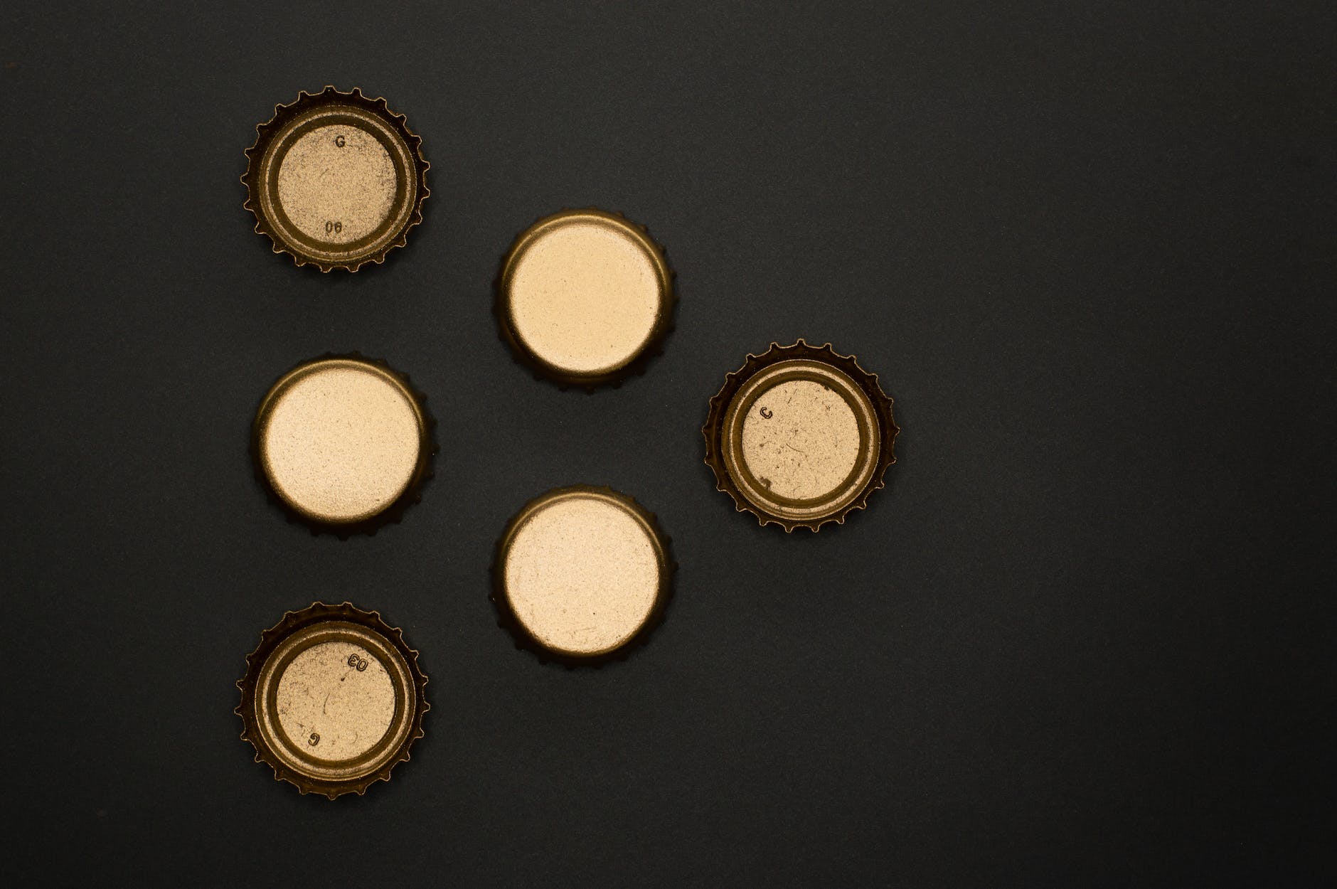 bottle caps on a black surface in close up photography