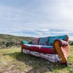 vintage abandoned couch on meadow in countryside