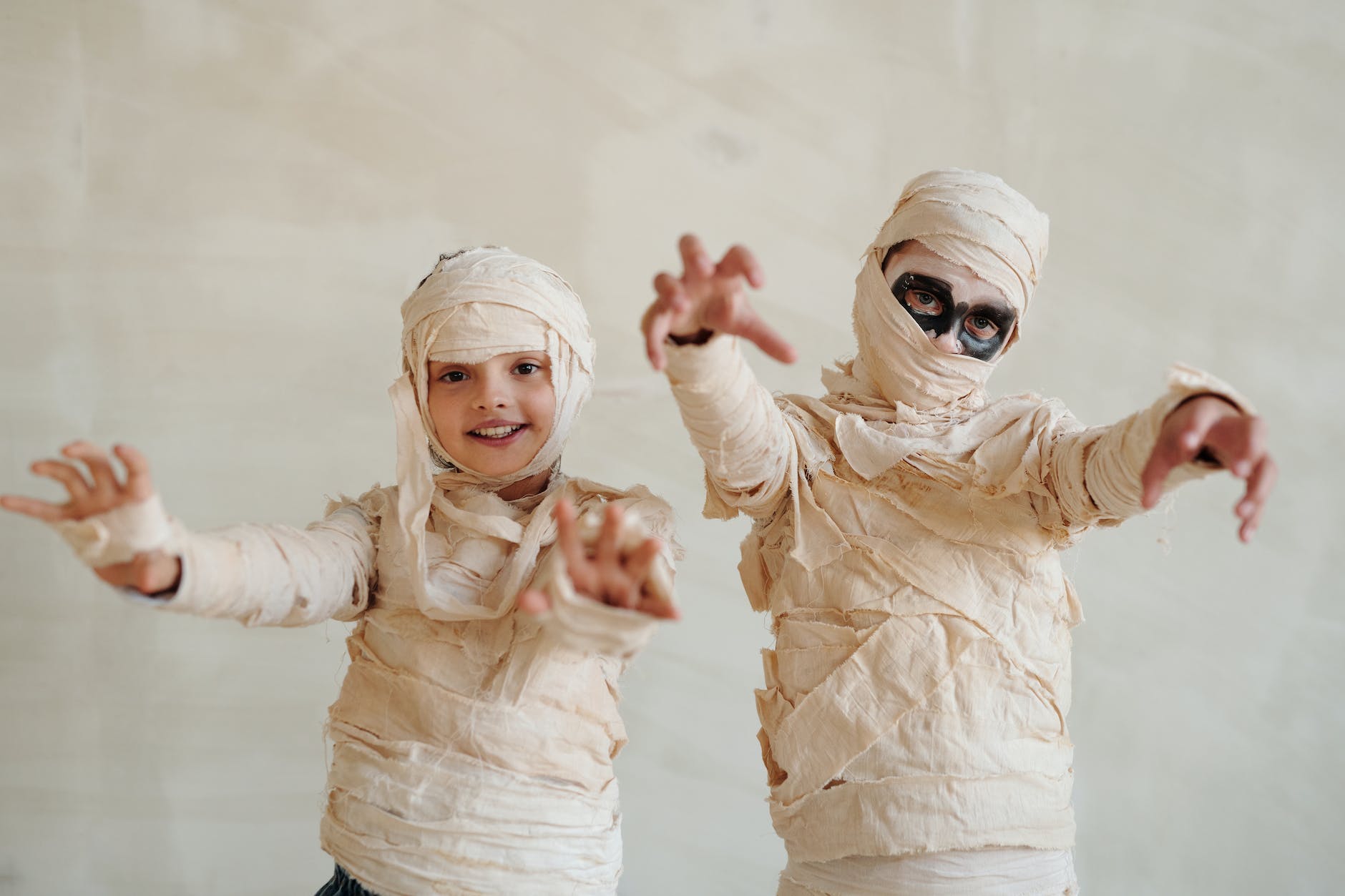 two kids wearing a mummy costume