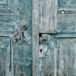 shabby wooden blue doors with rusted locks