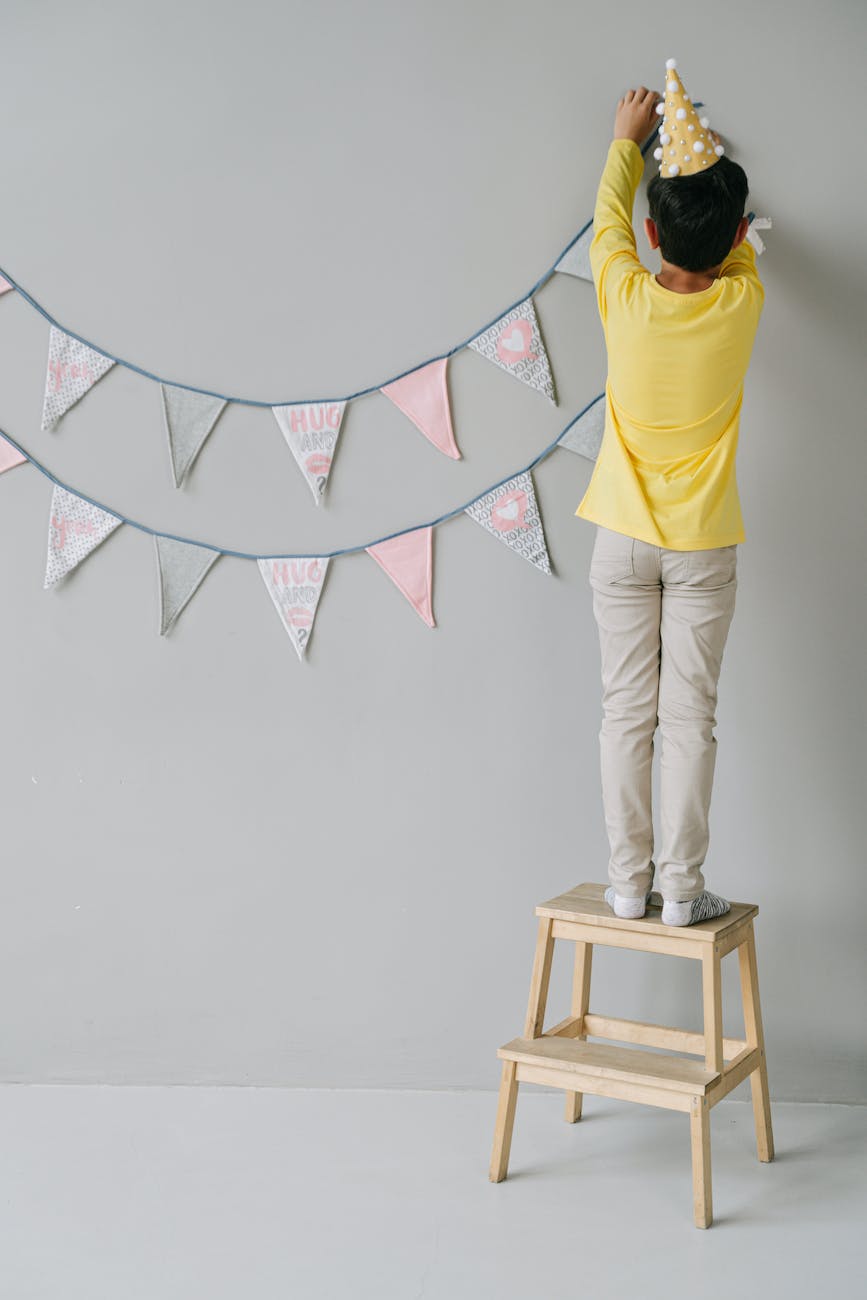 a person hanging a birthday banner
