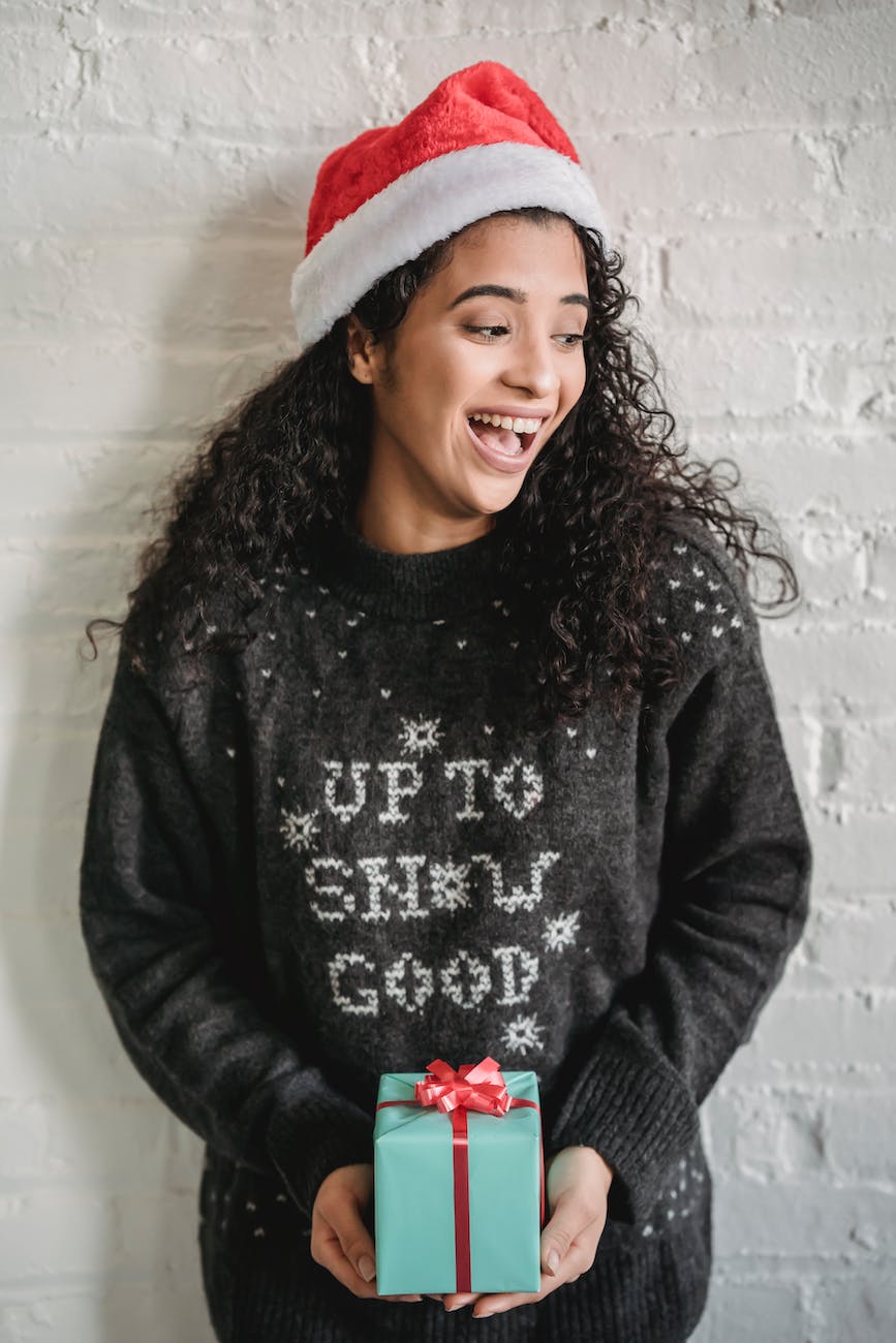 excited ethnic woman with christmas gift box