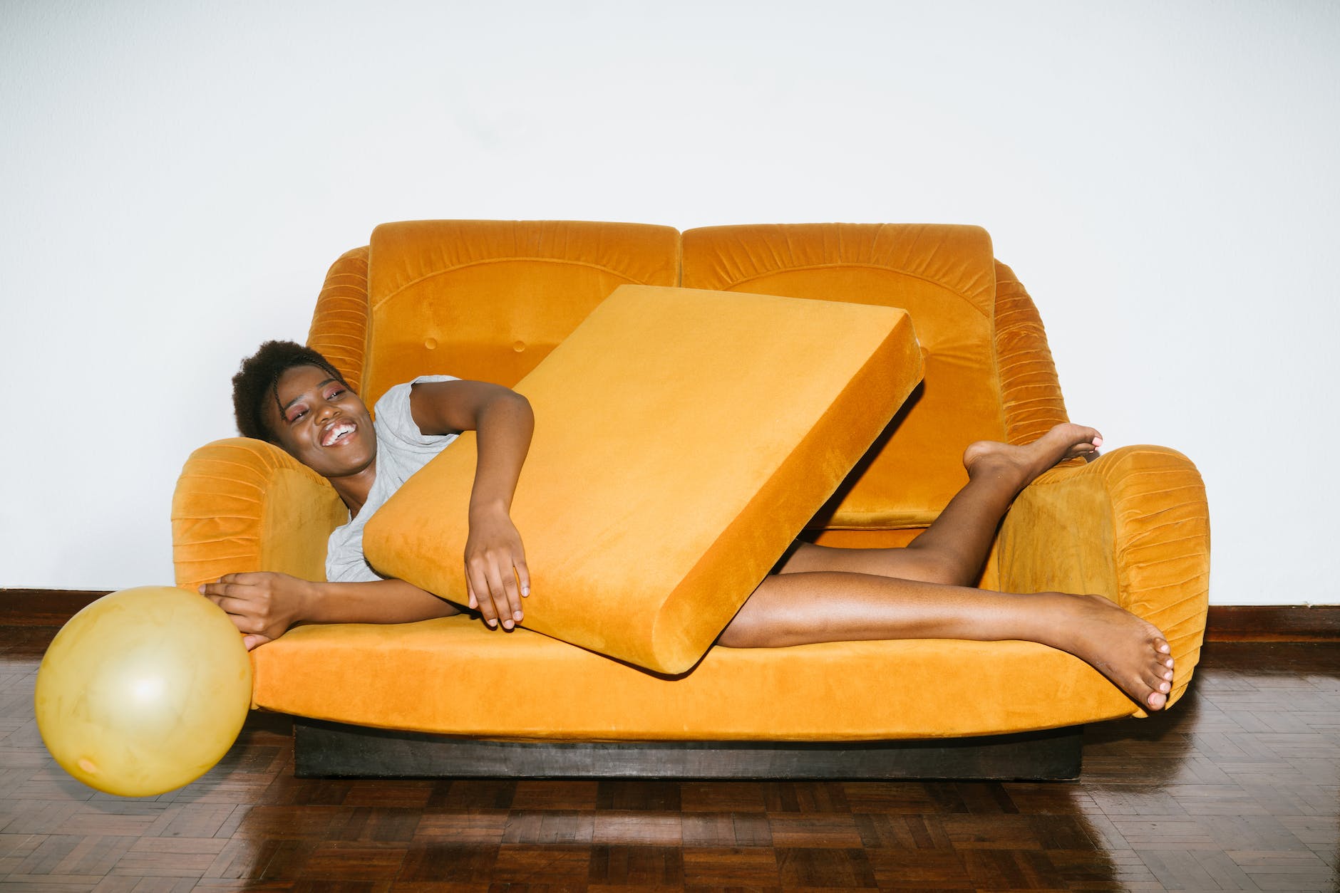 woman lying on orange sofa